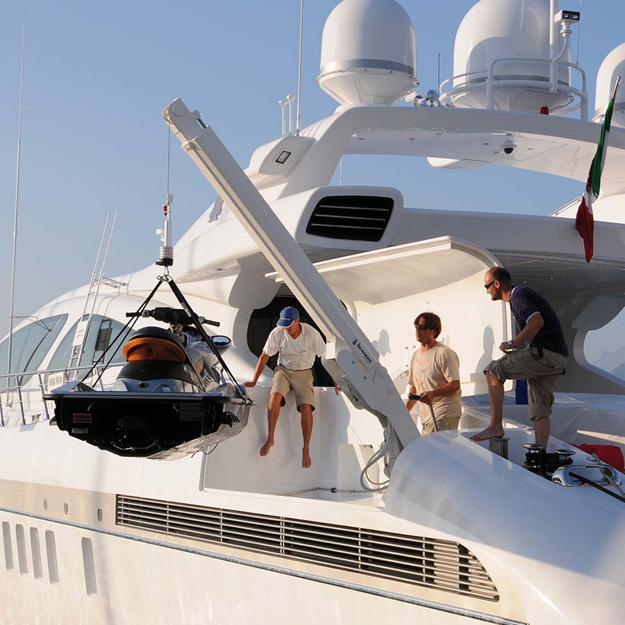 gru idraulica che sta manovrando una moto d'acqua utilizzando la sua estensione telescopica e il braccio inclinato