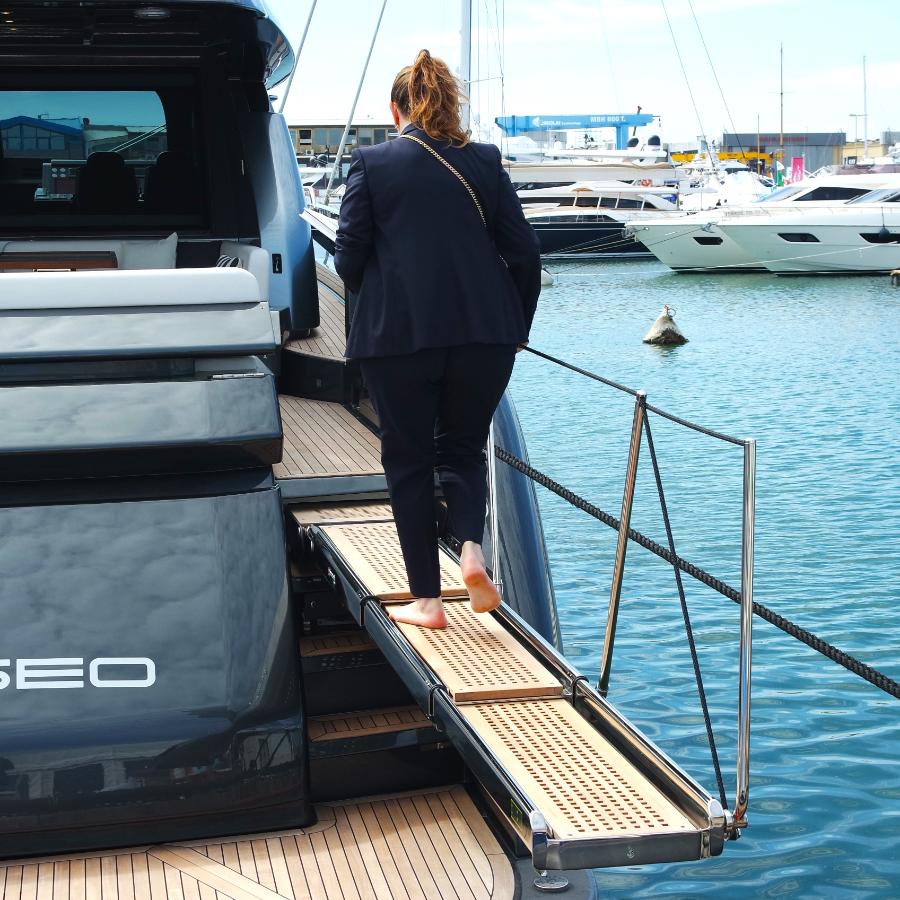 Ragazza che sta salendo su un'imbarcazione da diporto usando la passerella RIENTRANTE CON MOVIMENTAZIONE IDRAULICA PI 395